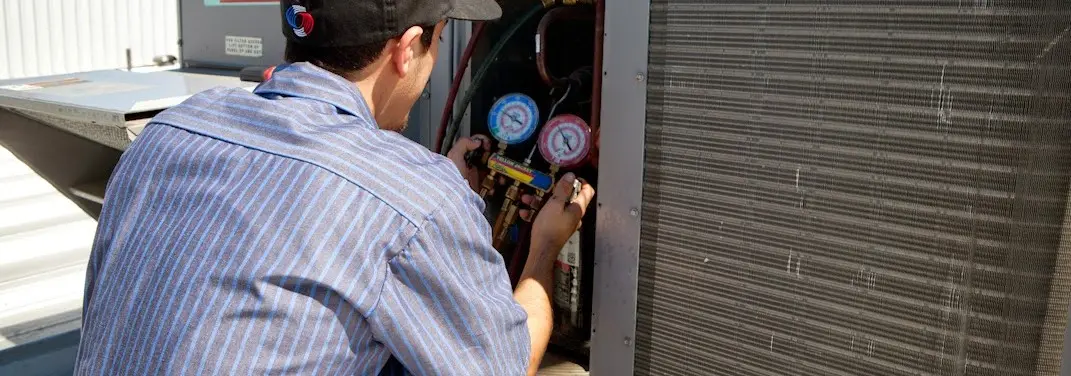 HVAC technician servicing a condenser unit in Shady Hollow